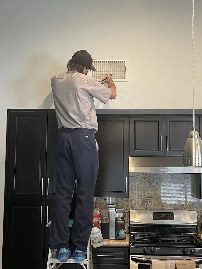 Technician inspecting an air vent during HVAC service in Lakeland